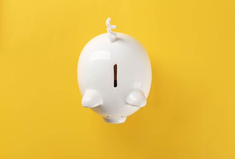 white piggy bank on solid yellow background