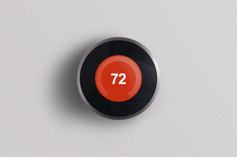 Nest Learning Thermostat on a grey wall displaying 72 degrees